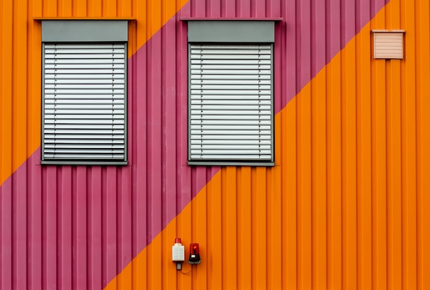 Free photo background of an orange and purple metal wall with white window blinders
