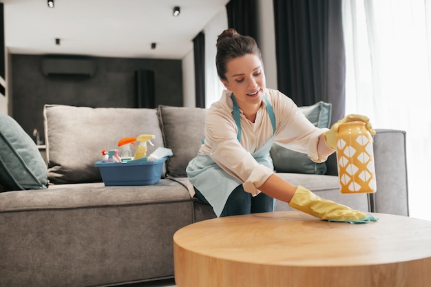 Free photo chores. a woman cleaning a table surfcase with disinfector