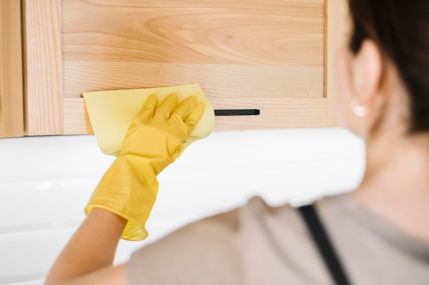 Free photo close-up woman cleaning cabinet