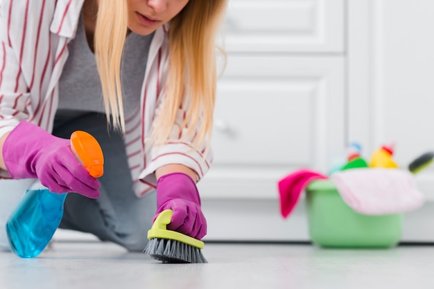 Free photo close-up woman spray cleaning floor