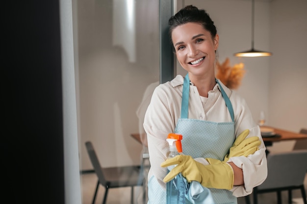 Free photo domestic routine. smiling housewife in apron standing in the kitchen
