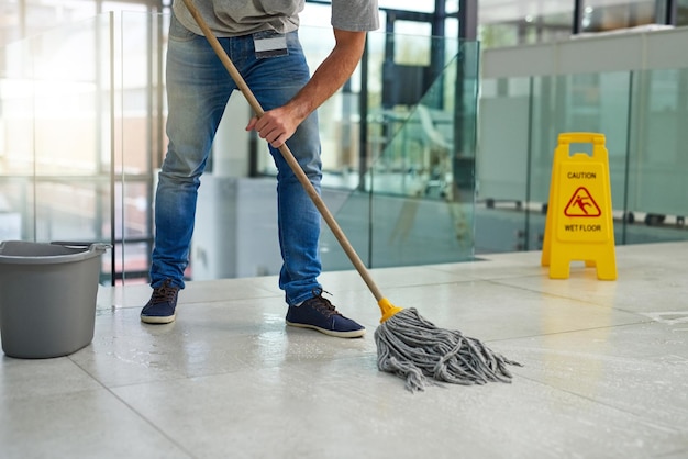 Photo hell leave that floor spotless shot of an unrecognizable man mopping the office floor