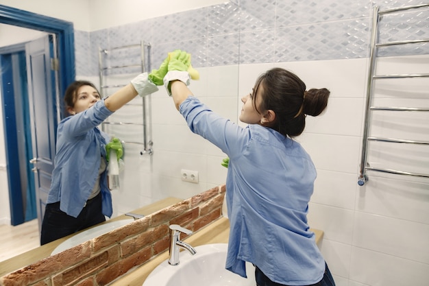 Free photo housewife woking at home. lady in a blue shirt. woman in a bathroom.
