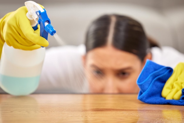 Photo make sure to be thorough shot of a young woman spraying cleaner on her coffee table