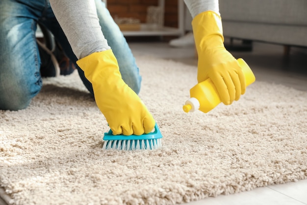 Photo mature man cleaning carpet at home, closeup