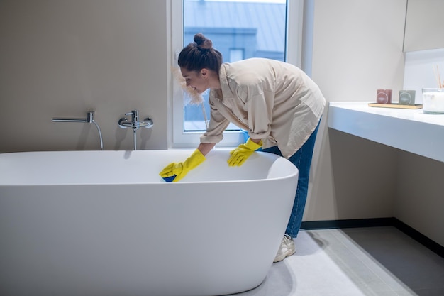 Photo a woman doing cleaning at home and disinfecting the bathroom