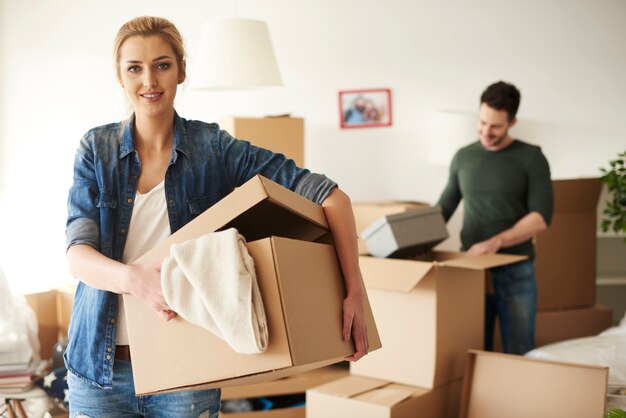 Free photo woman helping her boyfriend while moving house