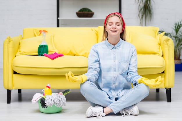 Free photo woman with cleaning gloves doing yoga