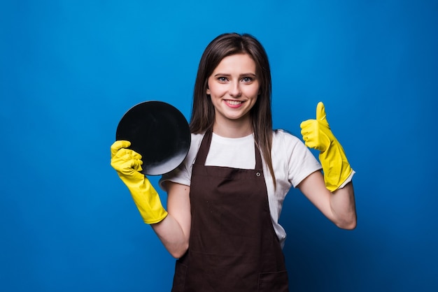 Free photo young housewife in gloves showing sponge and clean plate isolated